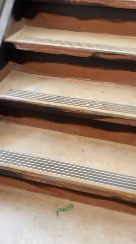 Before: stair flight with brown risers, pale treads and metal nosings