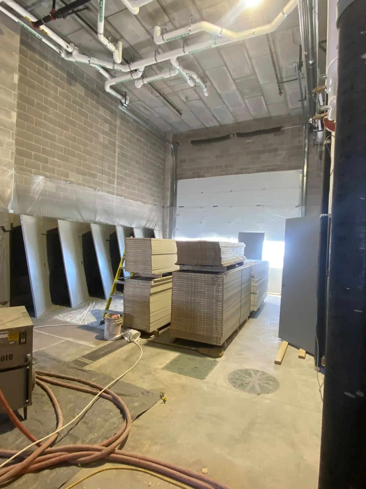 Commercial block-wall room with stacked materials and unfinished door openings