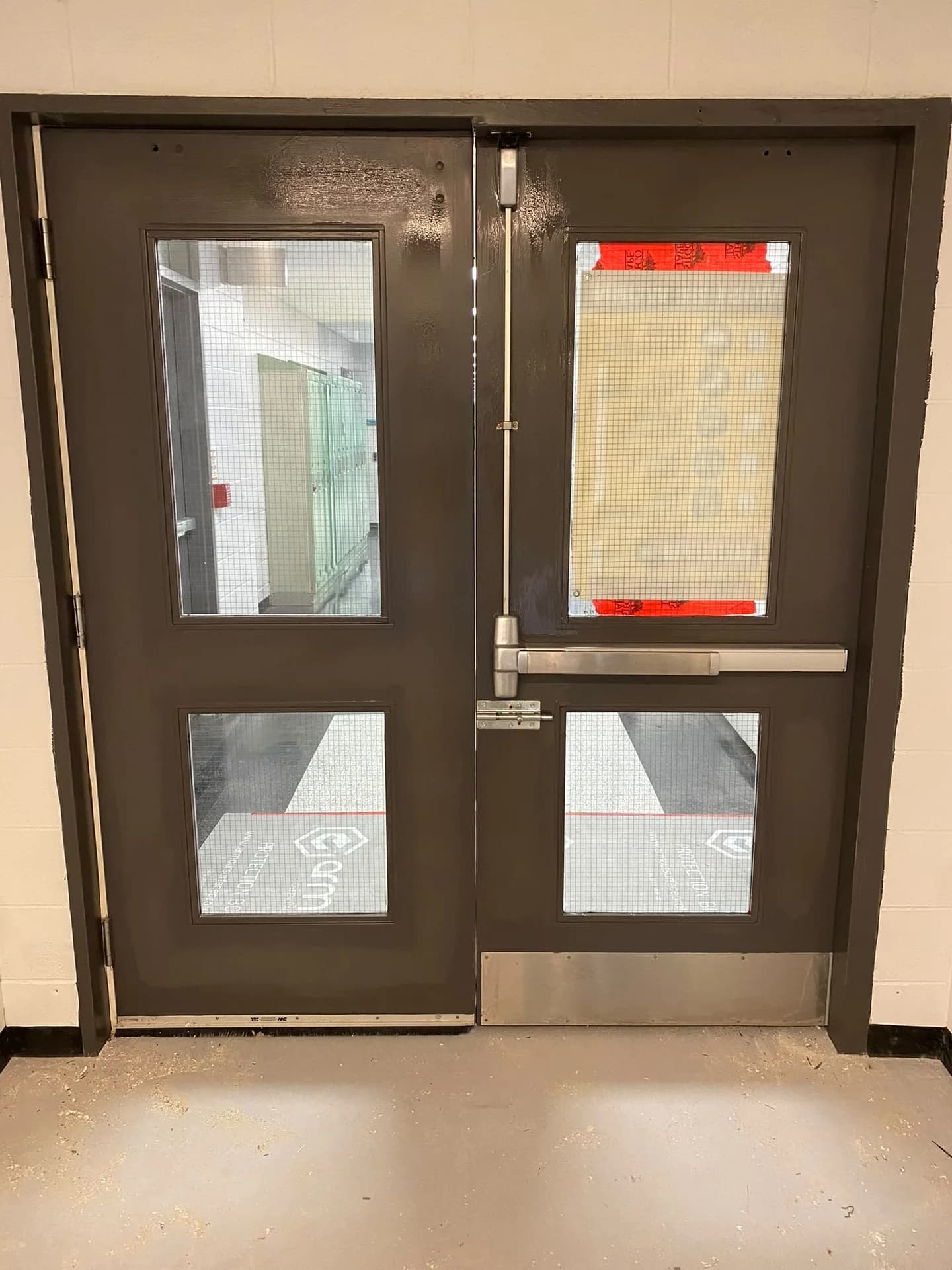 Dark double doors with protected glazed openings set in a light wall