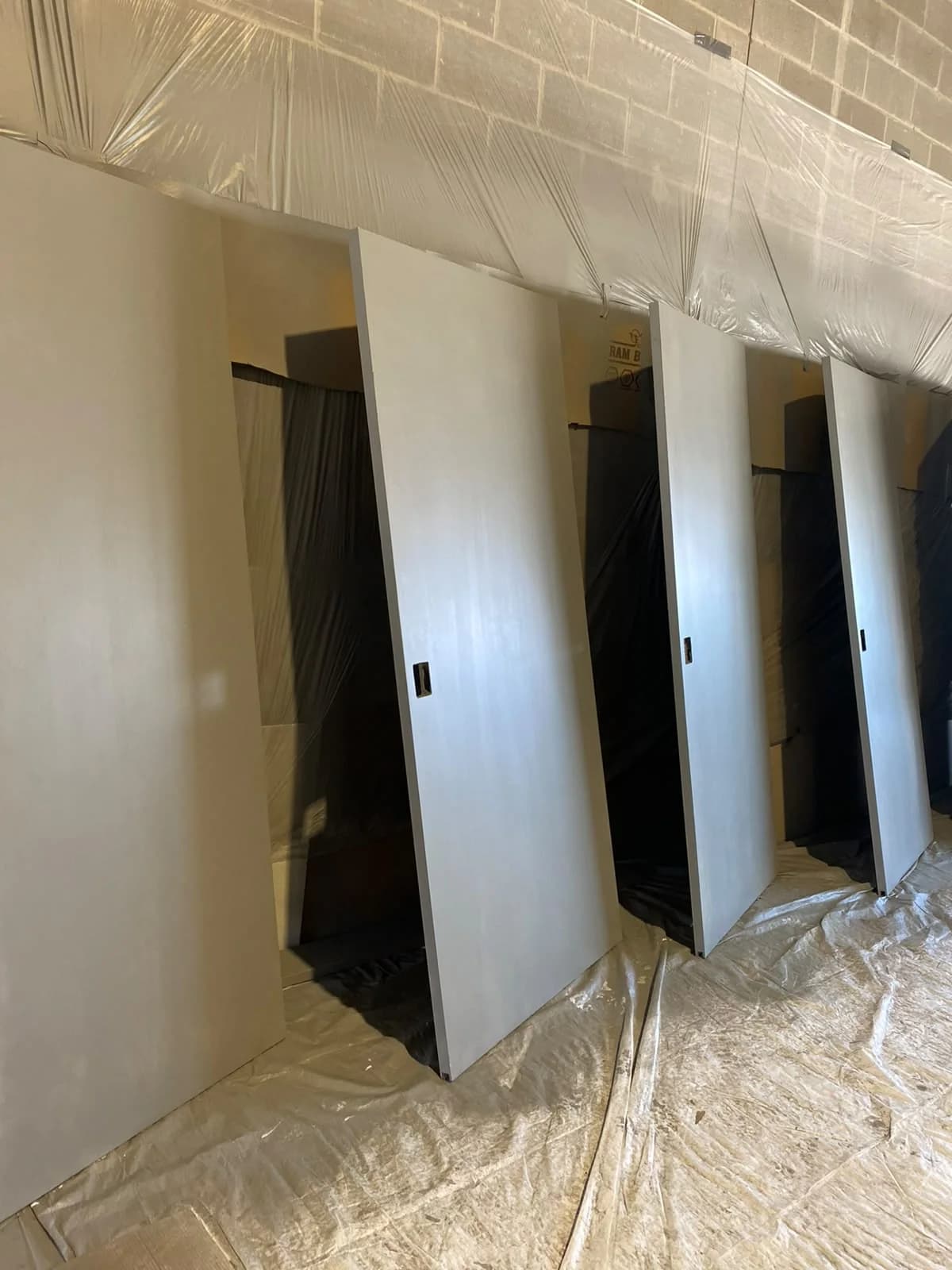 Commercial doorways surrounded by protective plastic and covered flooring