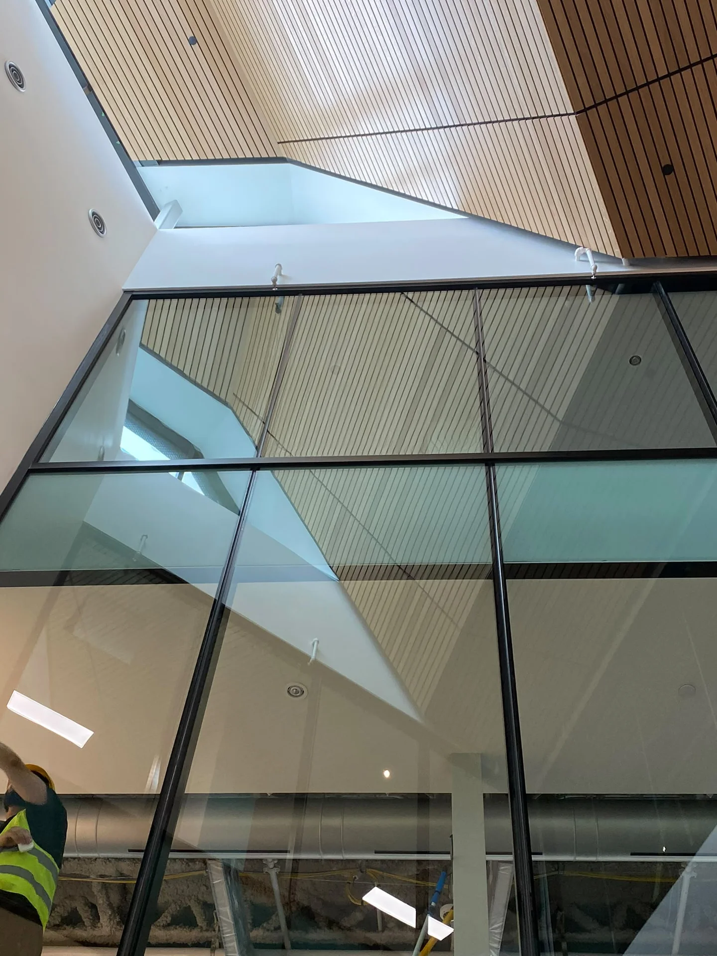 High light-coloured walls and glazing beneath a slatted wood ceiling